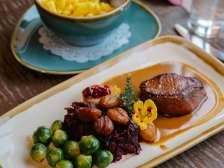 Assiette automnale de gibier avec viande, marrons, choux de Bruxelles et chou bleu