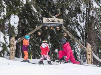 Deux enfants et une femme à l'entrée de la piste d'aventure du Flumserberg