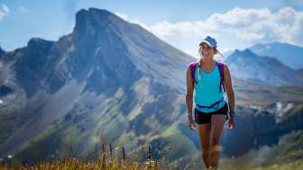 Une jeune femme en tenue d'été fait une randonnée sur le circuit des 7 sommets au Flumserberg