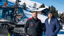 Le conducteur de Pistenbully Peter Thut se tient devant le présentateur Manuel Rothmund dans la neige.