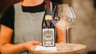Service à vin du château de Salenegg Une femme sert une bouteille de vin avec des verres