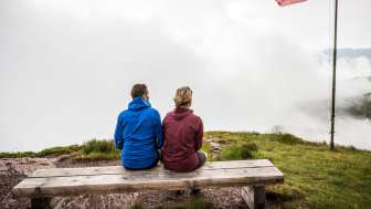 Randonnée par tous les temps Couple assis sur un banc dans le brouillard