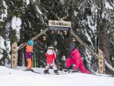 Deux enfants et une femme à l'entrée de la piste d'aventure du Flumserberg