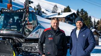 Le conducteur de Pistenbully Peter Thut se tient devant le présentateur Manuel Rothmund dans la neige.