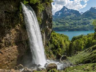 La cascade rugissante dre Rhinquelle avec vue sur le lac de Walenstadt et l'imposant Mürtschenstock