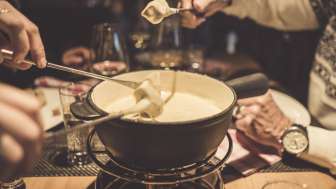 Plusieurs personnes savourent une fondue au fromage
