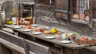 Table richement garnie de spécialités régionales dans un chalet d'alpage
